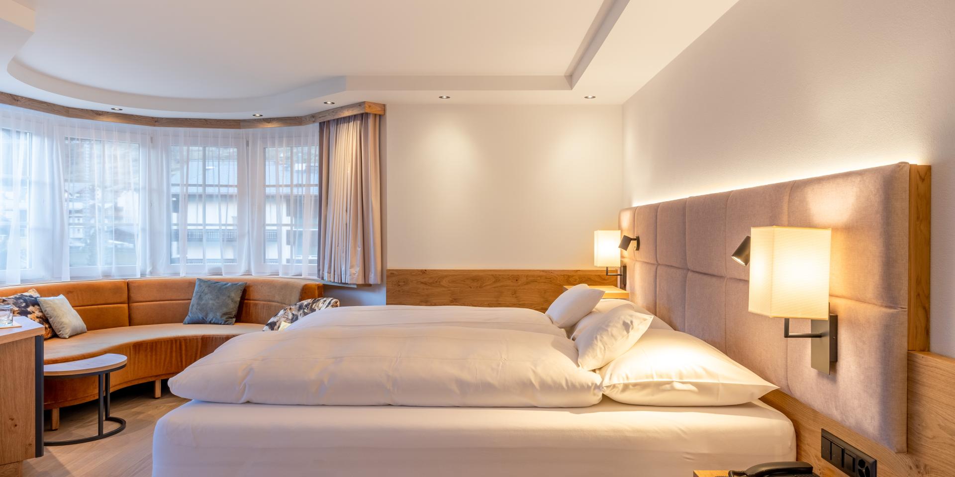 Modernes Zimmer im Resort La Ginabelle Zermatt mit Sitzbereich und Doppelbett