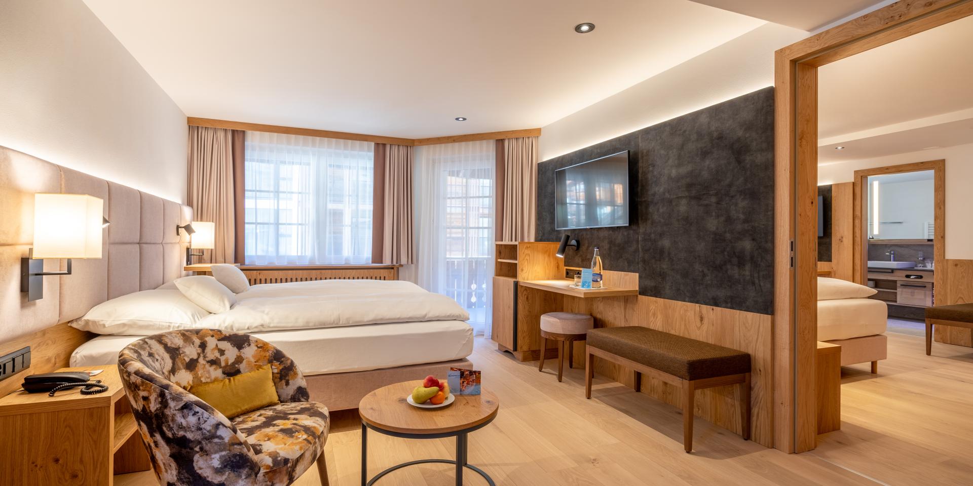 Moderne Zimmer im Resort La Ginabelle Zermatt mit gemütlicher Sitzgelegenheit und Balkon
