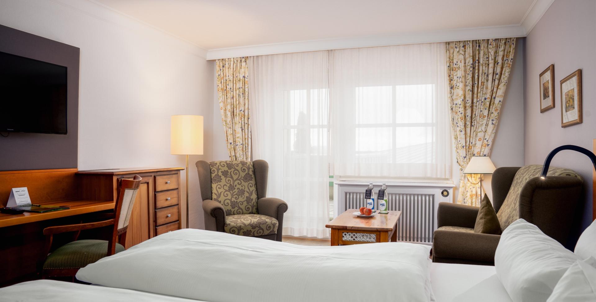 Gemütliches Zimmer im Sport- und Wellnesshotel Angerhof ****S mit Bett und Sitzbereich