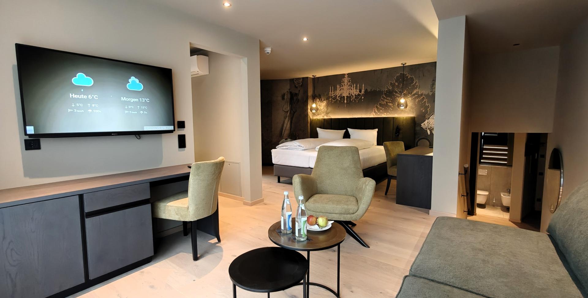 Modernes Hotelzimmer im Sport- und Wellnesshotel Angerhof ****S mit Sitzbereich und TV
