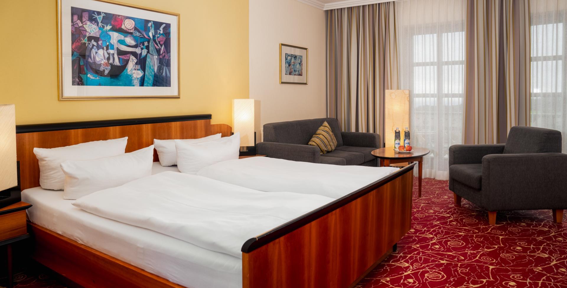 Gemütliches Zimmer im Sport- und Wellnesshotel Angerhof ****S mit Doppelbett und Sitzbereich