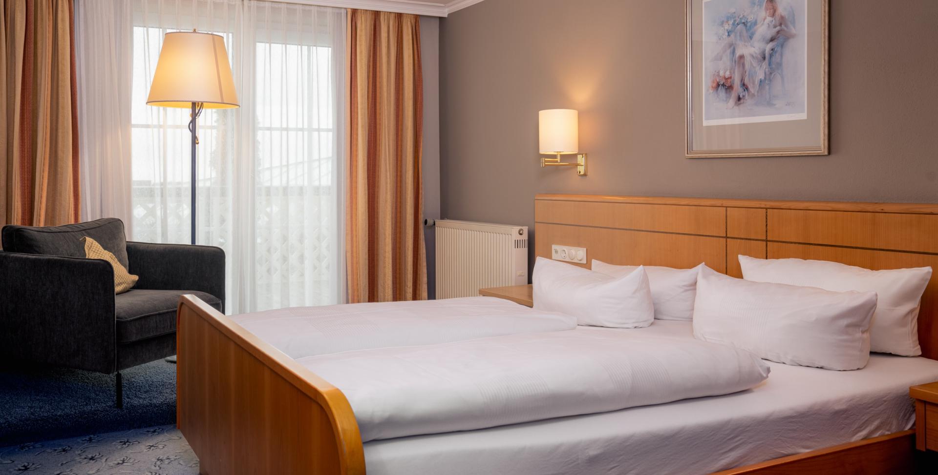 Gemütliches Zimmer im Sport- und Wellnesshotel Angerhof ****S mit Bett und Sitzbereich