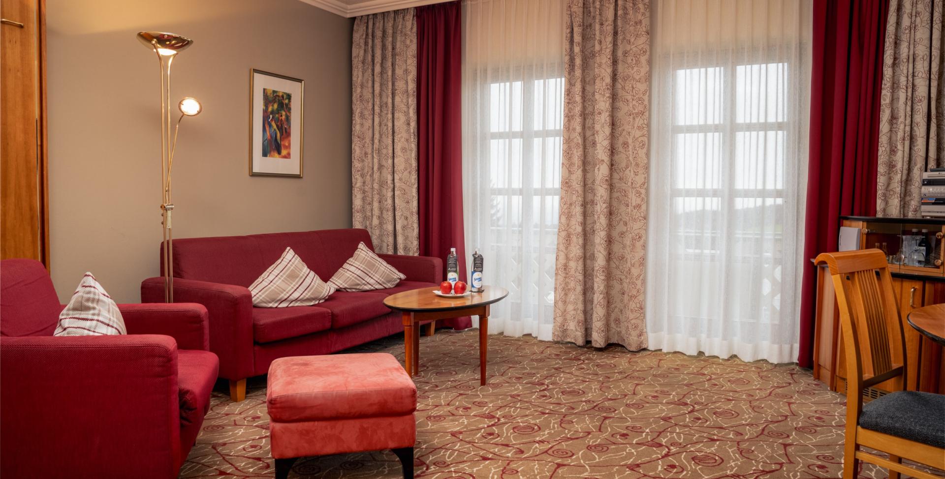Gemütlicher Wohnbereich im Sport- und Wellnesshotel Angerhof ****S mit roten Möbeln
