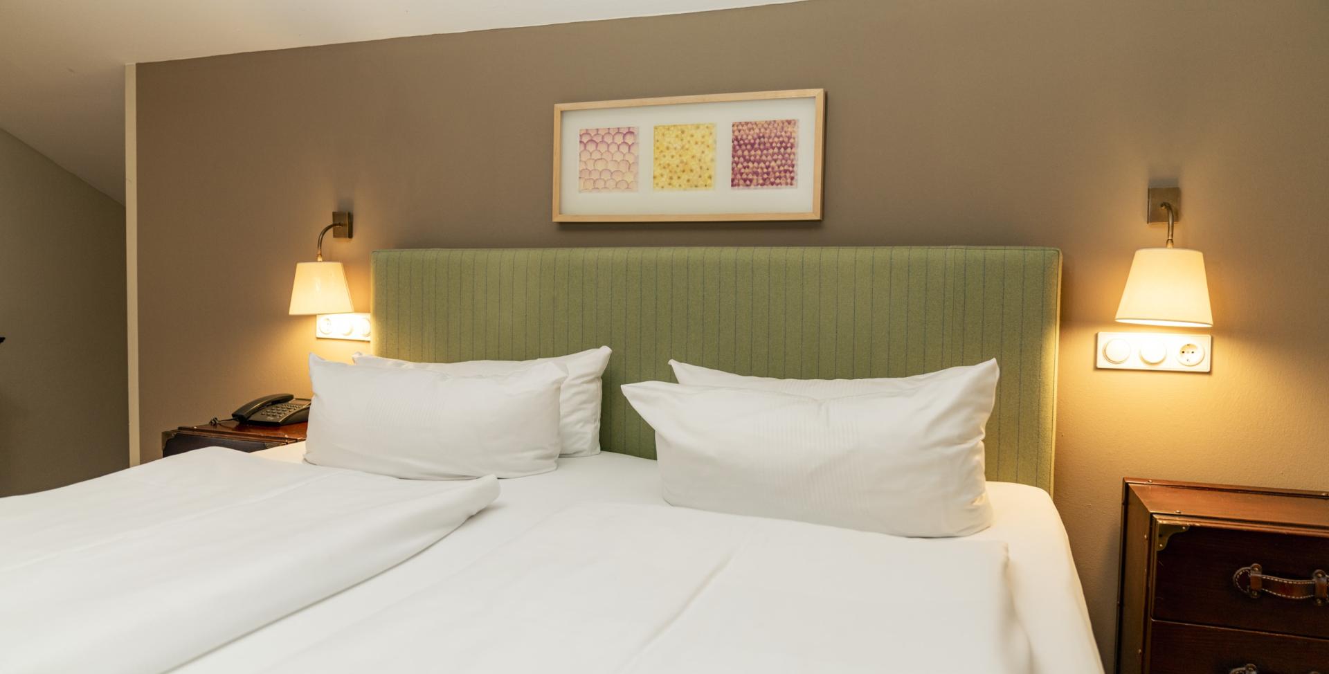 Modernes Hotelzimmer im Sport- und Wellnesshotel Angerhof ****S mit grünem Kopfteil