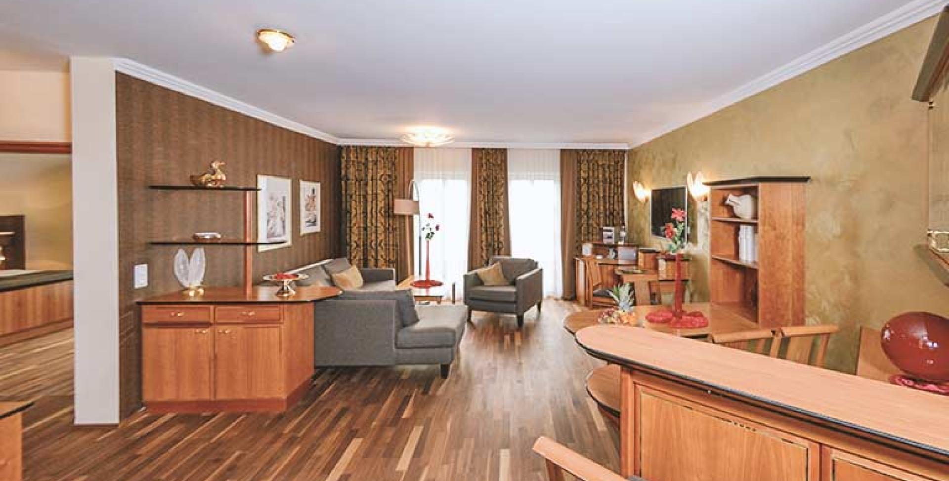 Gemütlicher Wohnbereich im Sport- und Wellnesshotel Angerhof ****S mit Holzmöbeln und Sofas