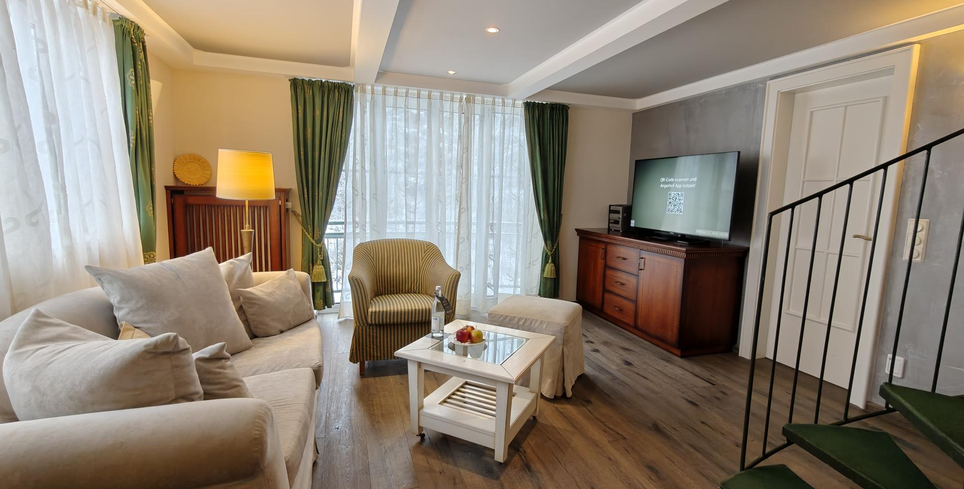 Gemütlicher Wohnbereich im Sport- und Wellnesshotel Angerhof ****S mit Sofa und TV
