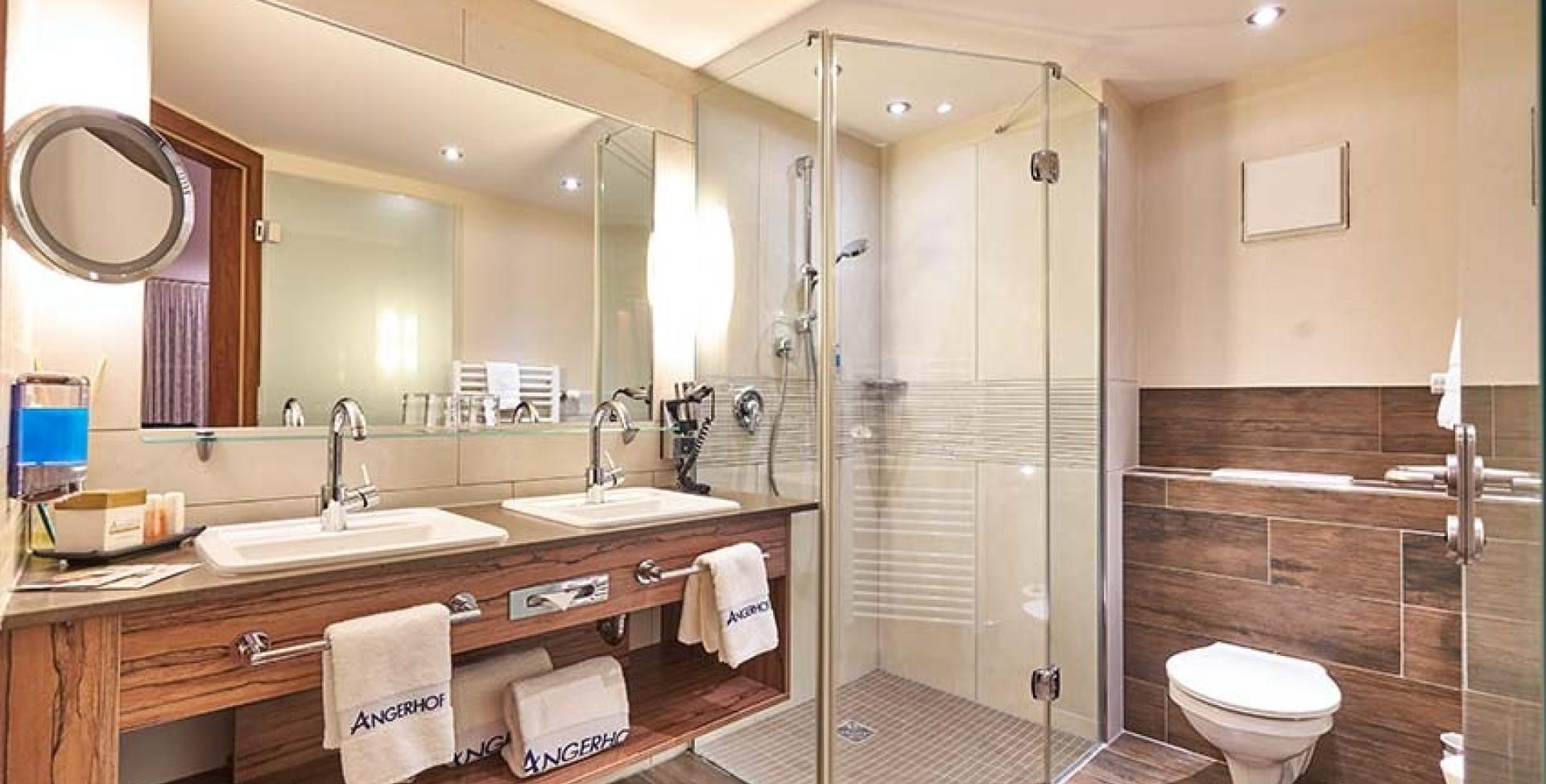Modernes Badezimmer im Sport- und Wellnesshotel Angerhof ****S mit Dusche und Waschbecken