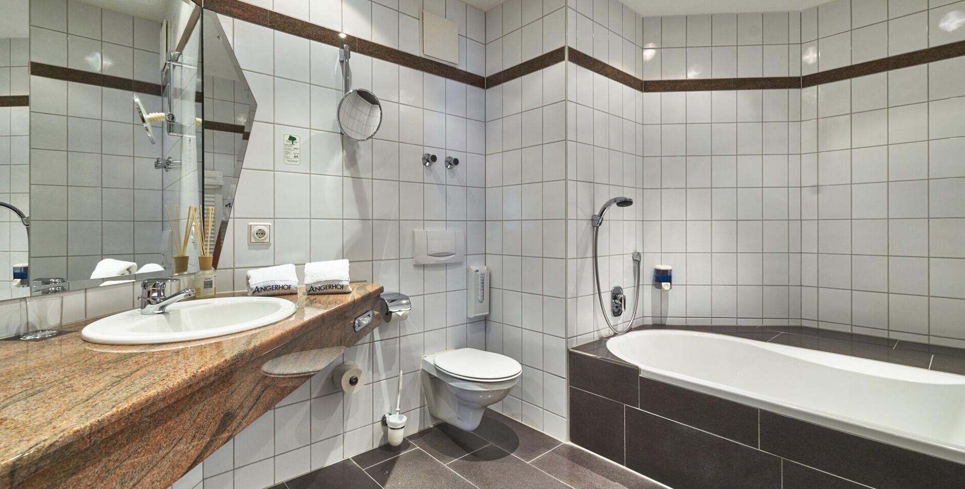Modernes Badezimmer im Sport- und Wellnesshotel Angerhof ****S mit Wanne und Waschbecken