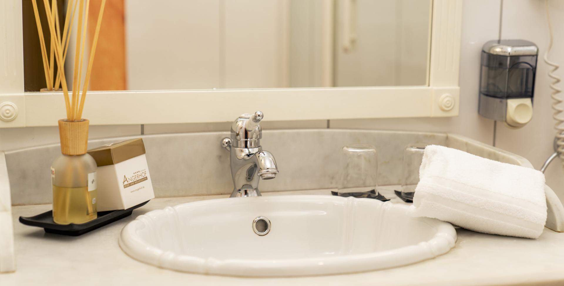 Waschbecken im Sport- und Wellnesshotel Angerhof ****S Bad mit Handtuch und Duftstäbchen