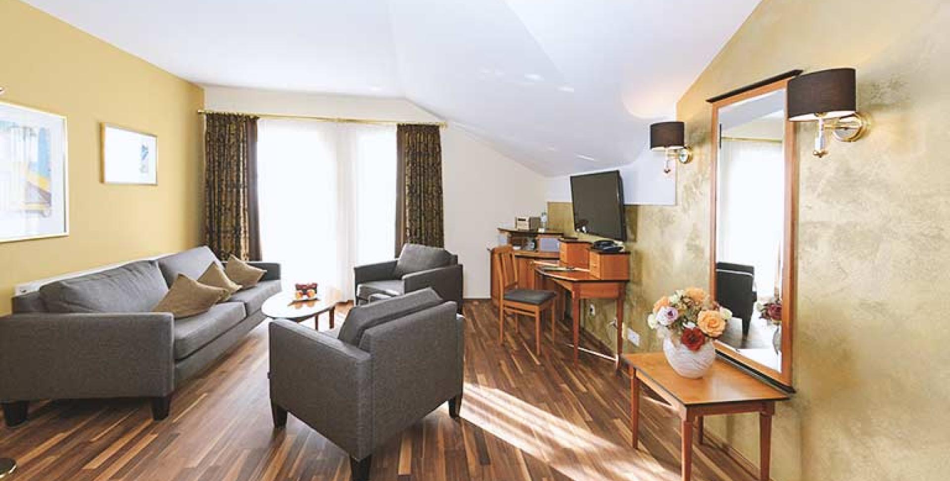 Gemütlicher Wohnbereich im Sport- und Wellnesshotel Angerhof ****S mit Sofas und TV