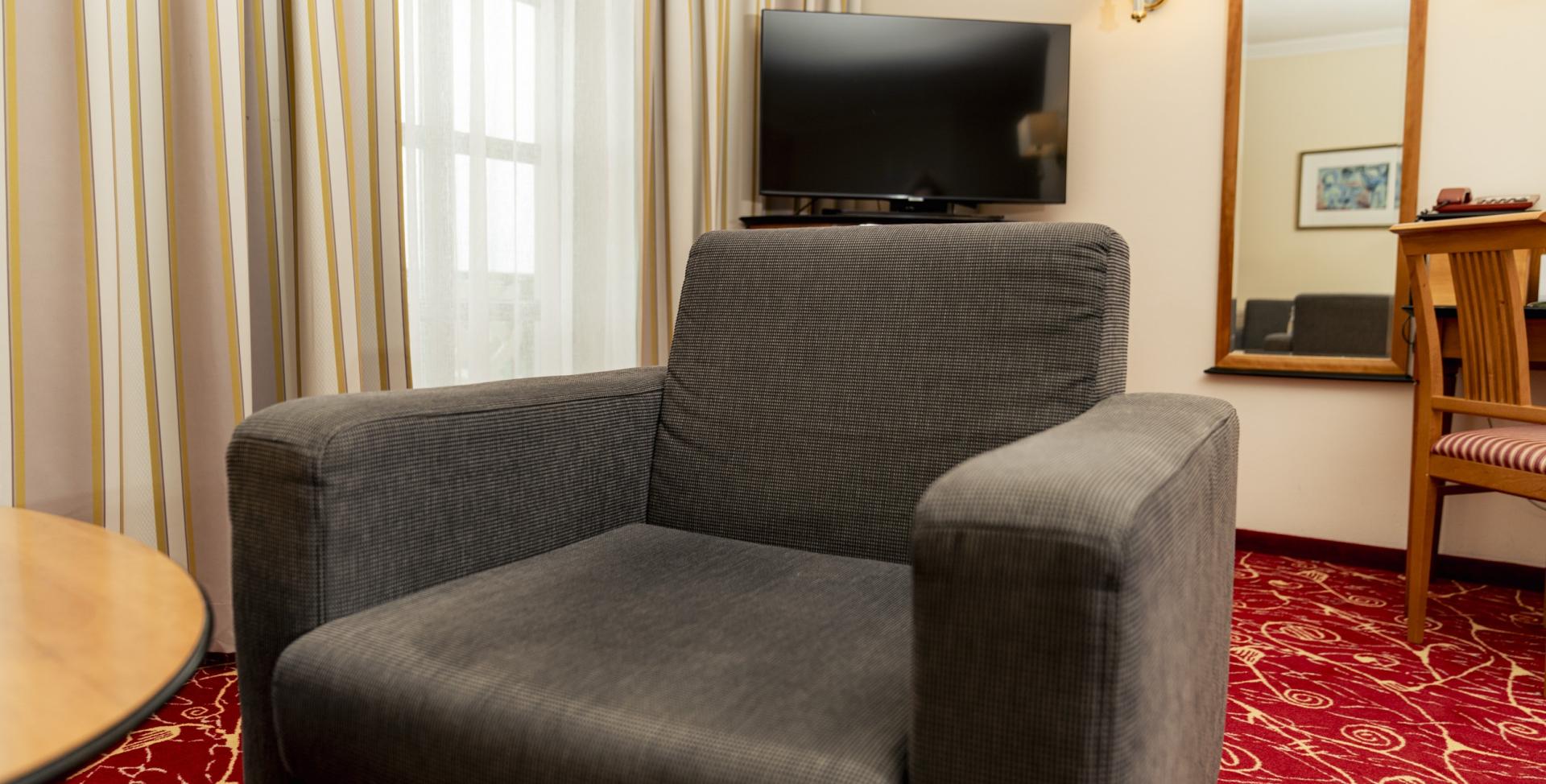 Gemütlicher Sessel und TV im Zimmer des Sport- und Wellnesshotel Angerhof ****S