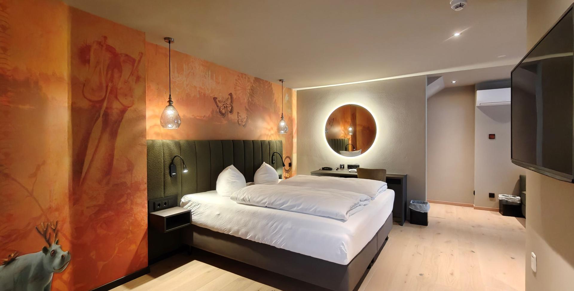 Modernes Hotelzimmer im Sport- und Wellnesshotel Angerhof ****S mit Doppelbett und Wandkunst