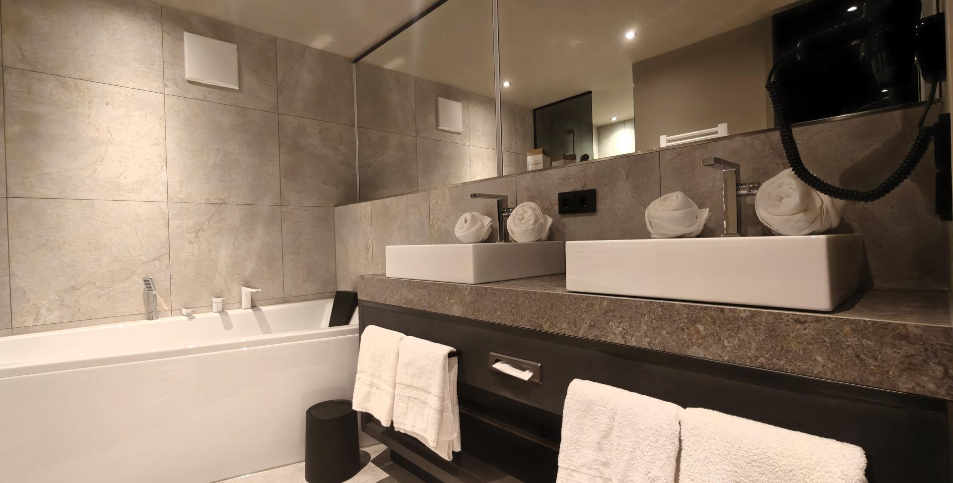Modernes Badezimmer im Sport- und Wellnesshotel Angerhof ****S mit Badewanne und Waschbecken