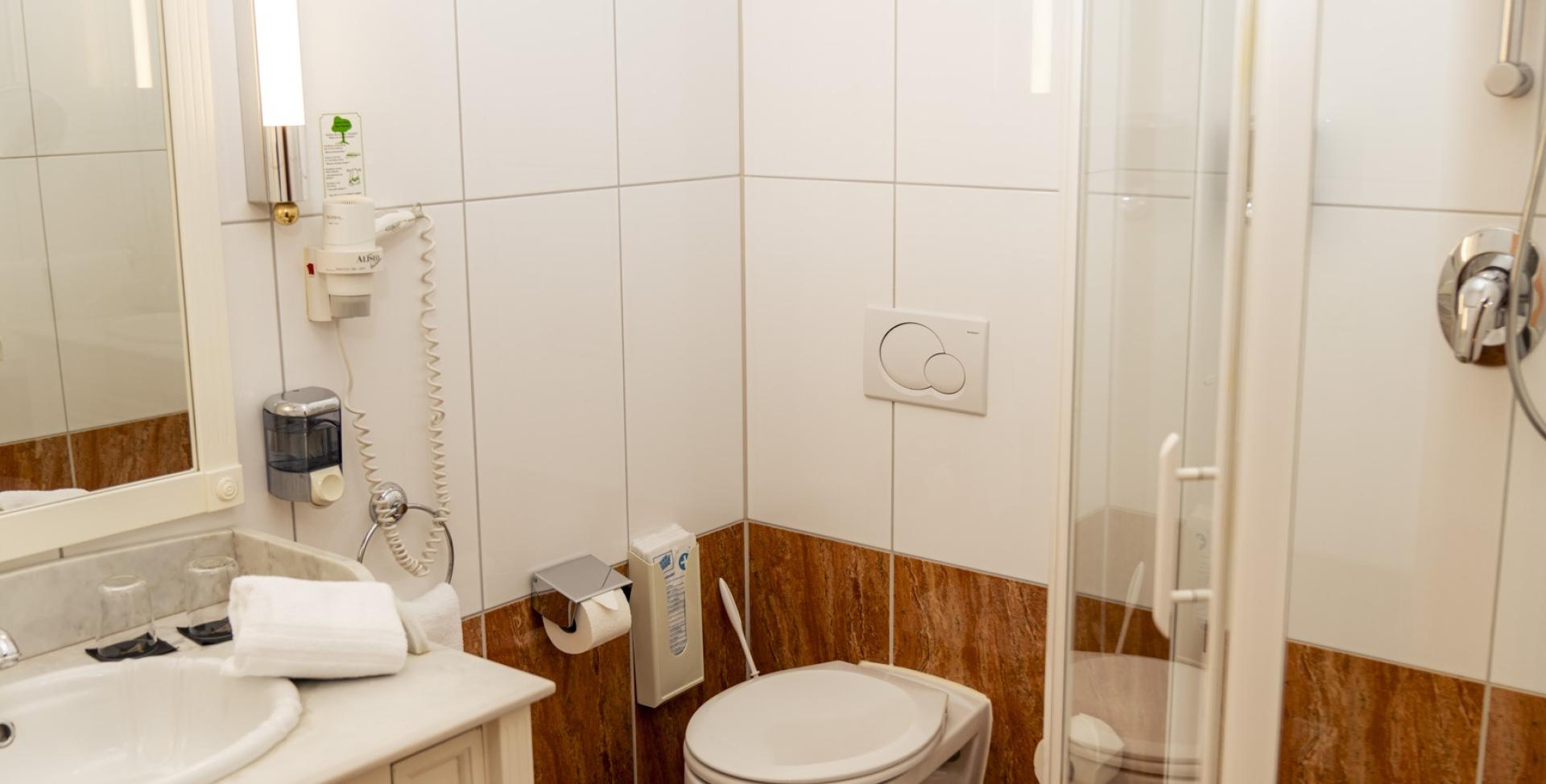 Helles Badezimmer mit Dusche im Sport- und Wellnesshotel Angerhof ****S.