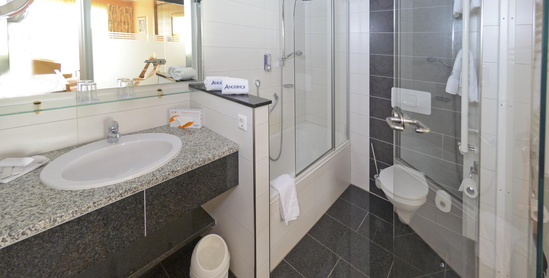 Modernes Badezimmer im Sport- und Wellnesshotel Angerhof ****S mit Dusche und Waschbecken