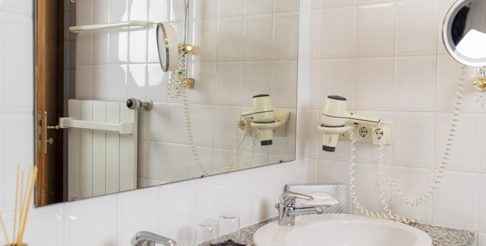 Badezimmer mit zwei Waschbecken im Sport- und Wellnesshotel Angerhof ****S.