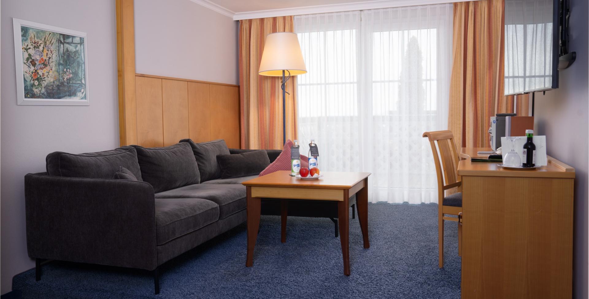 Moderner Wohnbereich im Sport- und Wellnesshotel Angerhof ****S mit Sofa und TV