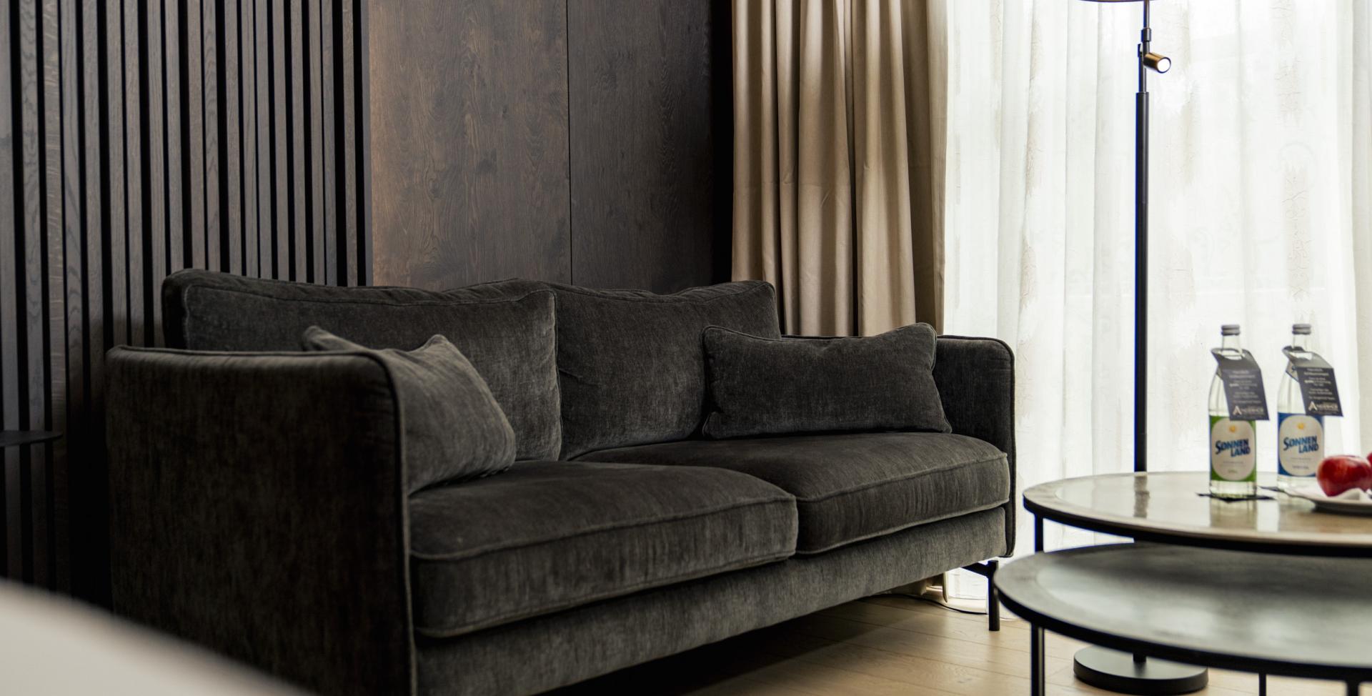 Moderne Sitzecke im Sport- und Wellnesshotel Angerhof ****S mit Sofa und Stehlampe