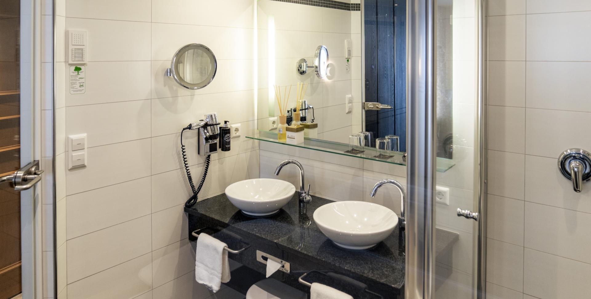 Modernes Badezimmer mit Doppelwaschbecken im Sport- und Wellnesshotel Angerhof ****S