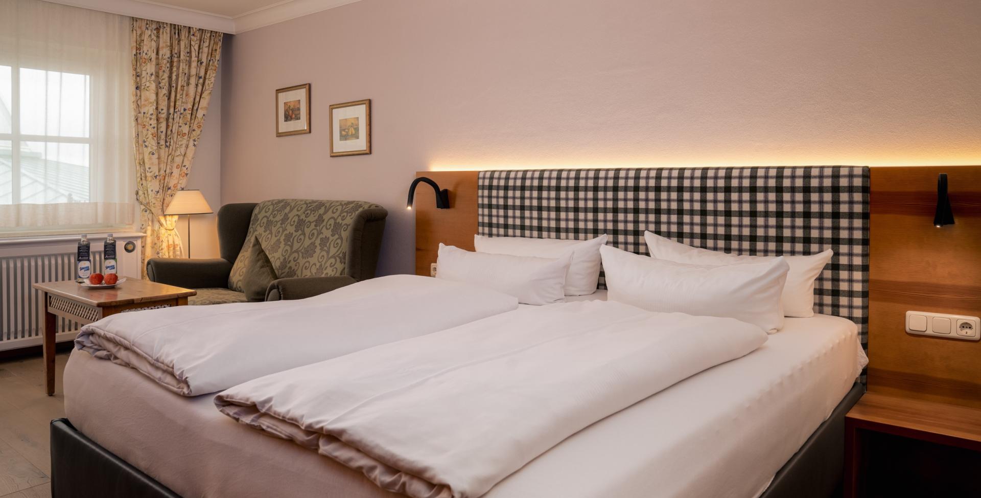 Gemütliches Gästezimmer im Sport- und Wellnesshotel Angerhof ****S mit Doppelbett und Sessel