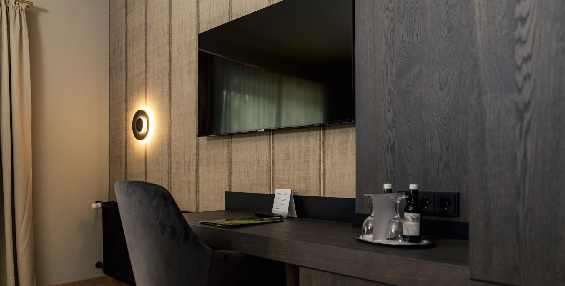Moderner Arbeitsbereich im Sport- und Wellnesshotel Angerhof ****S mit Fernseher und Sitzgelegenheit