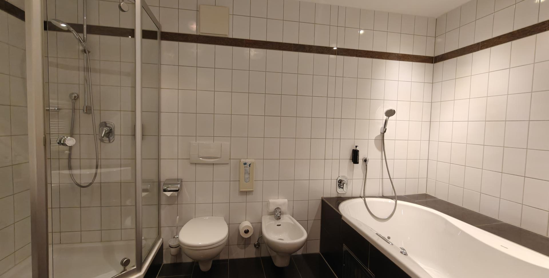 Modernes Badezimmer im Sport- und Wellnesshotel Angerhof ****S mit Dusche, Badewanne und WC.