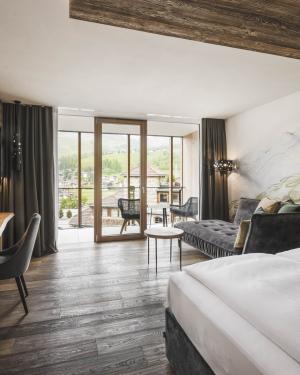 Modernes Gästezimmer im Excelsior Dolomites Life Resort mit Balkon und Bergblick