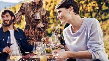 Gäste genießen Wein und Snacks im Hotel Waldsee im Freien