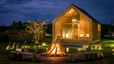 Seezeitlodge Hotel & Spa Außenansicht mit Feuerstelle und gemütlichem Beleuchtung abends