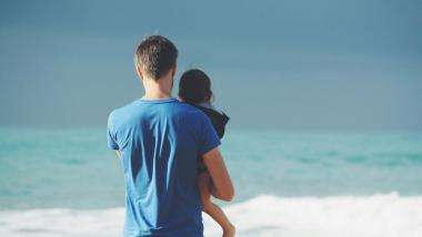 Padre che tiene un bambino sulla spiaggia con vista sul mare Regal Hotel Rimini