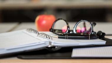 Land & Golf Hotel Stromberg Zimmer mit Lampe, Holztisch und rotem Sessel