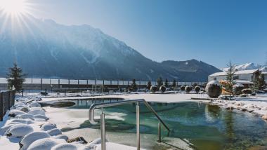 Winterlicher Außenpool mit Bergblick im Familienresort Buchau