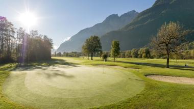 Der Dolomitenhof ***S Golfplatz mit Bergen im Hintergrund bei Sonnenlicht