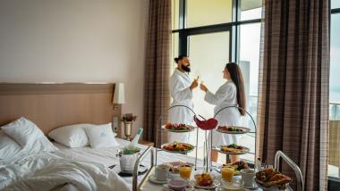 Paar im Bademantel stößt mit Wein im Parkhotel St. Leonhard Überlingen an