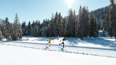 Langläufer auf einer sonnigen Loipe im verschneiten Wald beim Biohotel Leutascherhof
