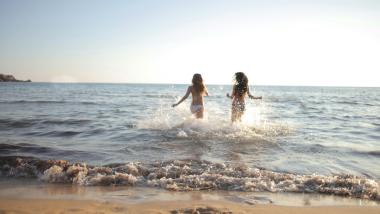 Le Rose Nuove Viserba due persone che giocano nel mare sulla spiaggia al tramonto