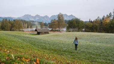 Person auf einer Wiese vor den Alpen beim Schlosshotel Kitzbühel
