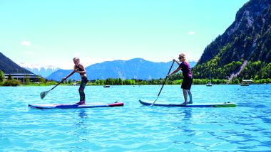 Zwei Personen paddeln auf Stand-Up-Paddle-Boards am Familienresort Buchau
