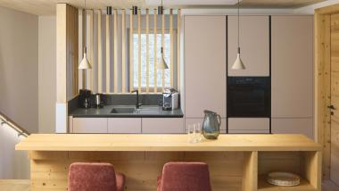 Moderne Küche im Hochfeldhof mit Holztheke und roten Stühlen