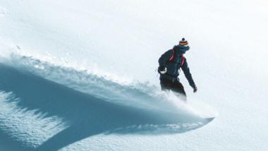Snowboarder fährt Pulverschnee im Sporthotel Silvretta Montafon Gaschurn