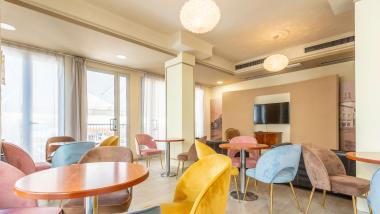 Sala luminosa e moderna con sedie colorate a Le Rose Nuove Viserba