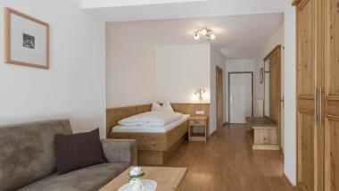Hotel Waldsee Zimmer mit Holzmöbeln, Bett und Sofa