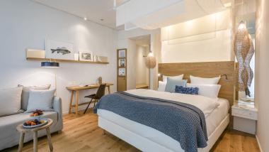 Modernes Schlafzimmer im Seezeitlodge Hotel & Spa mit Bett, Sofa und Schreibtisch