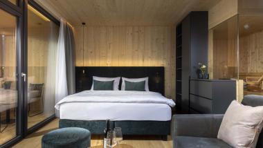 Der Dolomitenhof ***S moderne Holzschlafzimmer mit Bett und Sitzbereich