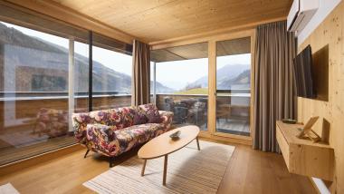 Gemütliches Wohnzimmer mit floralem Sofa und Blick auf Berge im Hochfeldhof