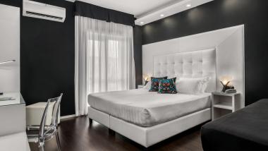 Camera doppia moderna al Reggia Suite Spa Hotel con elegante design bianco e nero