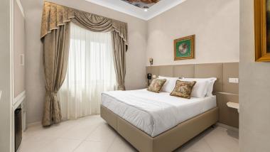 Camera elegante all'Hotel Regina Caserta con soffitto decorato e tende