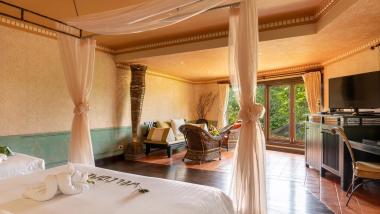 Cozy room with seating and beds at The Mangosteen Ayurveda & Wellness Resort
