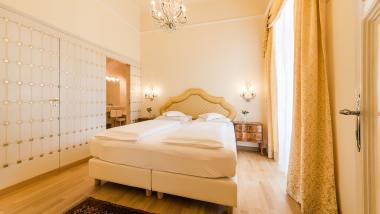 Elegant bedroom at Hotel Adria with double bed and antique furniture