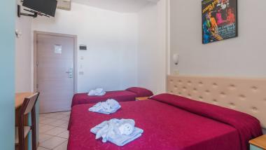 Camera d'albergo con due letti e decorazioni di fiori sugli asciugamani